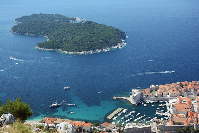 Bild som visar den lummiga ön Lokrum strax utanför Dubrovniks kust och stadskärna.